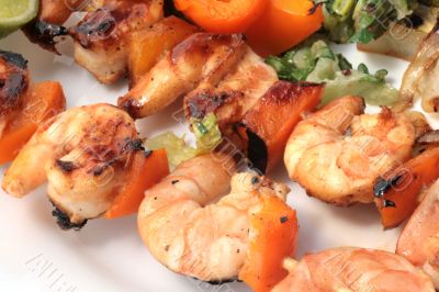 Grilled prawns on bamboo sticks served with salad and grilled ve