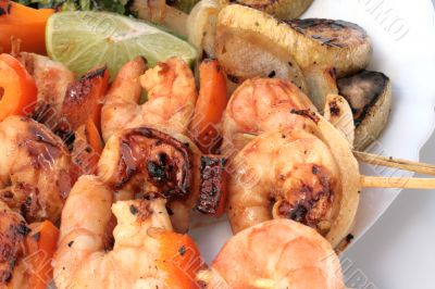 Grilled prawns on bamboo sticks served with salad and grilled ve