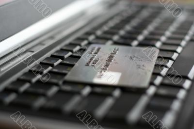 A shot of a laptop and a credit card in an office environment, can be used as e-commerce concept