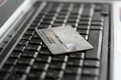 A shot of a laptop and a credit card in an office environment, can be used as e-commerce concept