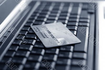 A shot of a laptop and a credit card in an office environment, can be used as e-commerce concept