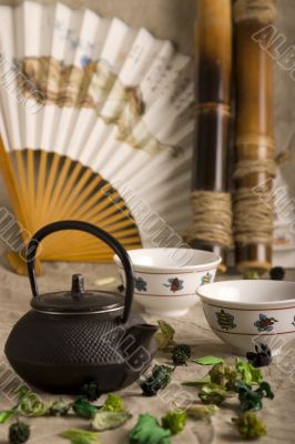 The Chinese teapot, two cups, fan and bamboo