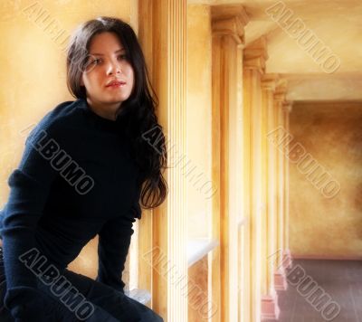 The girl sits at a window in a hall