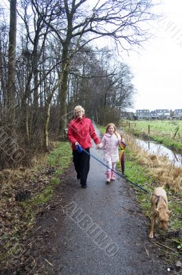 grandmother and grandchild walking with the dog