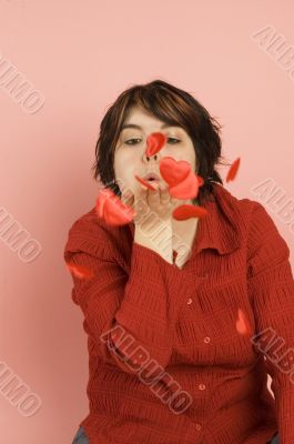 beautiful woman blowing feathers