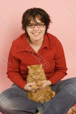young beautiful woman holding a domestic red cat