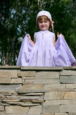 child in gown standing on wall