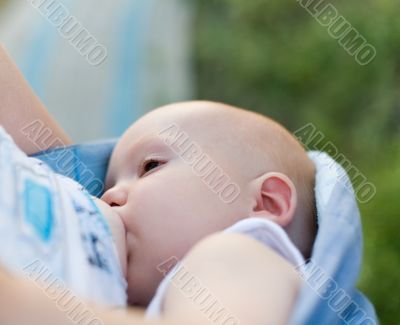 Mother breast feeding her infant in sling