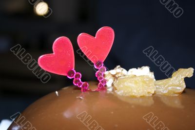Glazed chocolate cake with two red lovely hearts