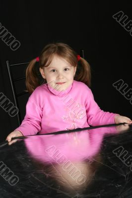 Child on dark background, keeps in hand reflector