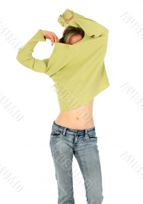 Woman in jeans takes off a green sweater
