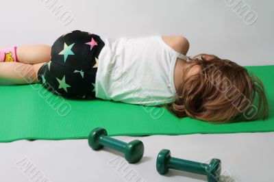 Small girl is tired to make power training.
