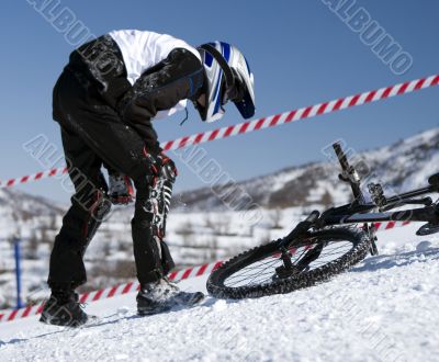 Snow biker downhill in winter mountains