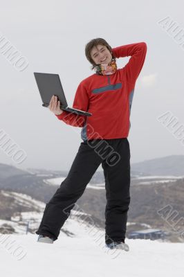 Happy teens with laptop in winter mountains