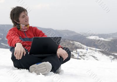 Happy teens with laptop in winter mountains
