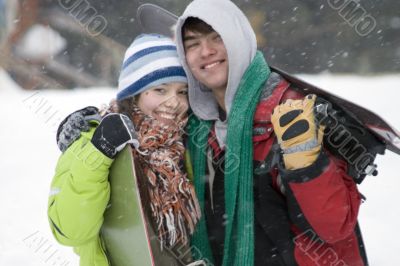 A lifestyle image of two teens snowboarders