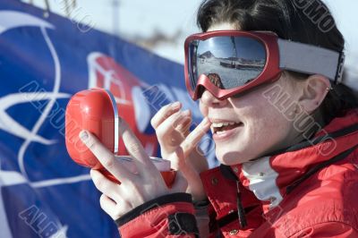 Attractive sport girl snowboarder applying face