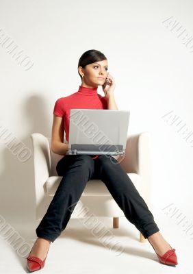 Atractive brunet businesswoman with Laptop and phone