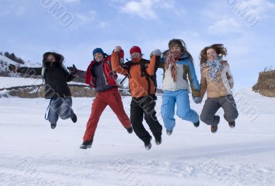 Group of sports teenagers jumping in mountains
