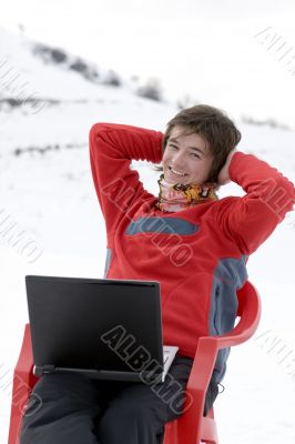 Happy teens with laptop in winter mountains