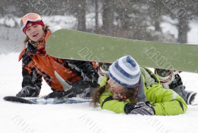 A lifestyle image of two young  snowboarders