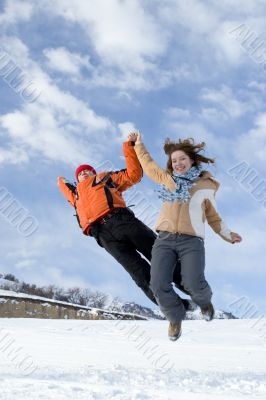 Couple jump over blue sky in winter Couple jump over blue sky in winter