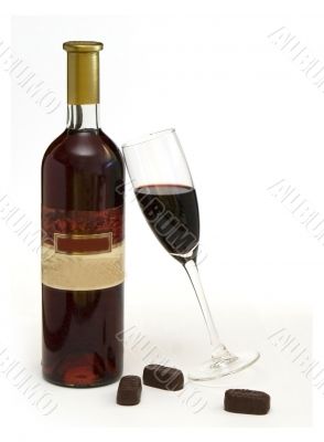 Bottle and wineglass with wine and chocolate candy