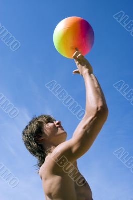 Happy sport build teenager boy with ball in beach