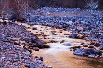 Mountain stream and lilac stones in Tien Shan