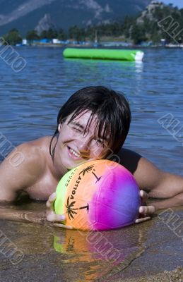 Teenager with variegated ball on the beach