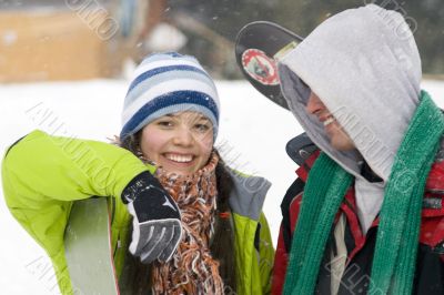 A lifestyle image of two young snowboarders