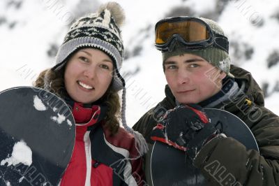 A lifestyle image of two young adult snowboarders