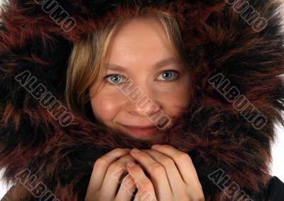 Smiling young woman with a fur hood