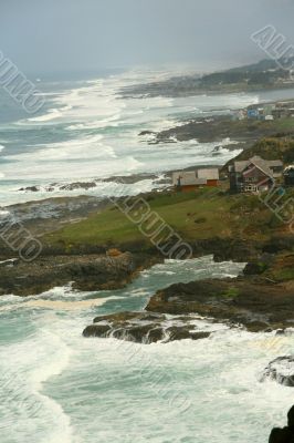 Surf with homes along rugged coastline