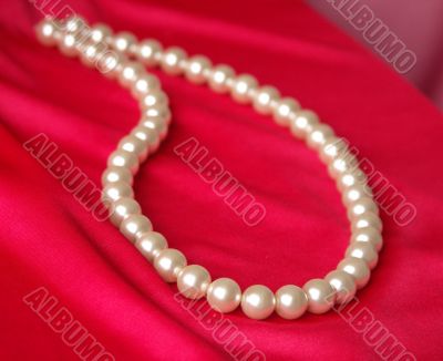 Pearl necklace on a red background