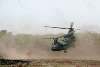 Helicopter taking off in dustcloud