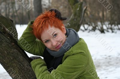 A beautiful blue eyed young woman near tree