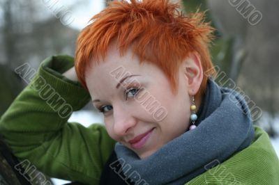 A beautiful blue eyed young woman near tree