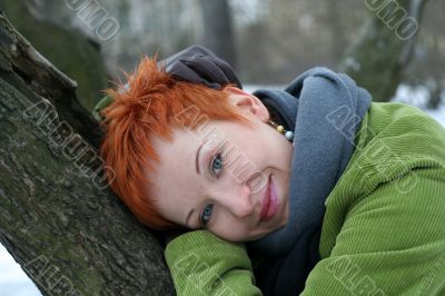 A beautiful blue eyed young woman near tree