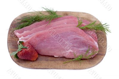 Raw pork schnitzel with dill and a strawberry