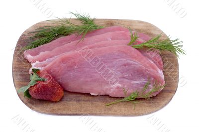 Raw pork schnitzel with dill and a strawberry Raw pork schnitzel with dill and a strawberry