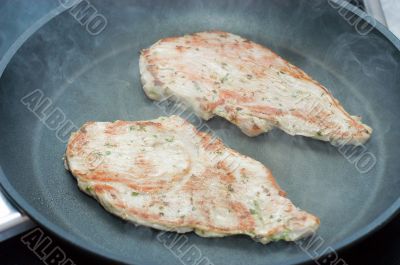 Fried schnitzel on a teflon frying pan