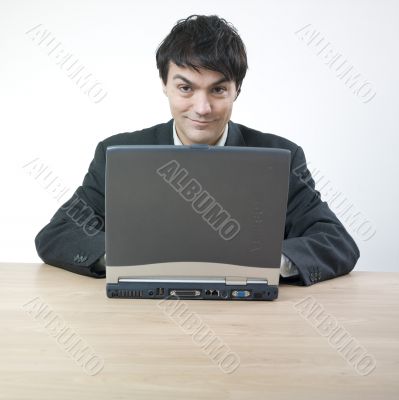 Businessman smiling behind computer