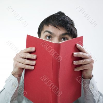 Man hiding his face with book