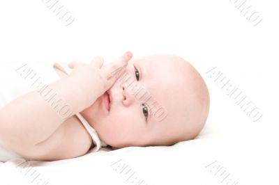 Boy lie on back on white bed