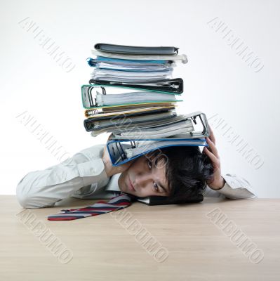 Businessman`s head crunched by folders