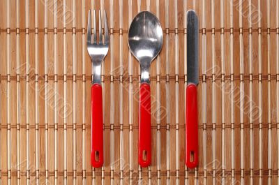 Spoon, fork and knife on bamboo background Spoon, fork and knife on bamboo background