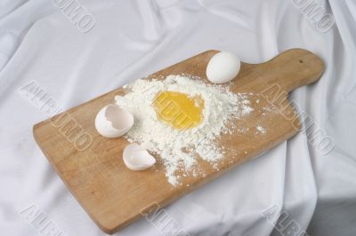 Eggs and a flour on a board