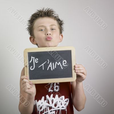 Boy and blackboard with je t`aime written on it