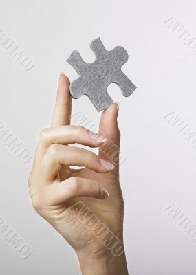Hand holding puzzle piece